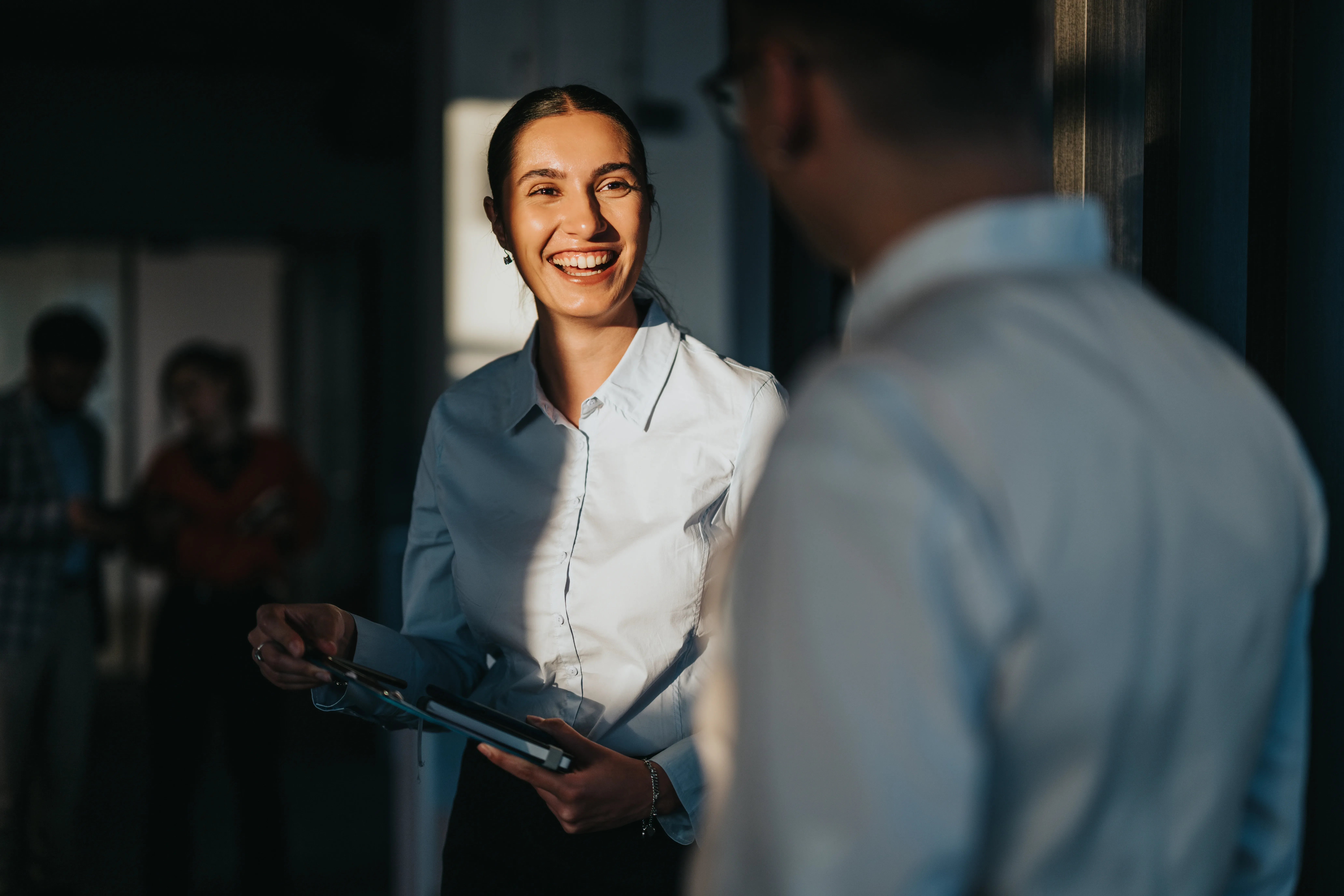Lady smiling whilst talking to colleague in the office